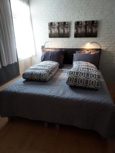 罗斯马伦B&B de Sluis的一张床上有两个枕头的房间