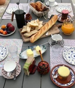 莫雷卢安河Hôtes de Maïa Chambre d'hôtes的餐桌,带食物、面包和奶酪盘