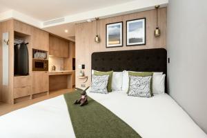 曼彻斯特Wilde Aparthotels Manchester St. Peters Square的卧室配有一张白色大床和绿色地毯