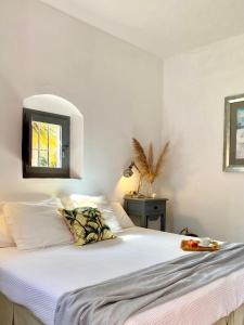 塔里法科尔蒂霍萨尔瓦多波苏埃罗酒店的一间卧室配有一张带白色床单的床和一扇窗户。