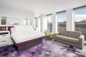 格拉斯哥YOTEL Glasgow的一间卧室配有一张床、一张沙发和窗户。