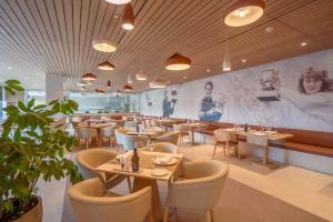 马纳科尔Rafa Nadal Residence的一间带桌椅的餐厅以及一堵带照片的墙壁