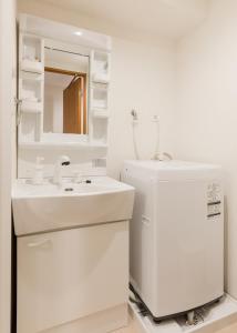 东京Dash Living Shinjuku的白色的浴室设有水槽和镜子