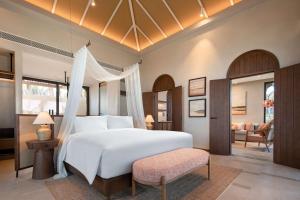 潘切Radisson Resort Phan Thiet的卧室配有一张白色大床和一把椅子