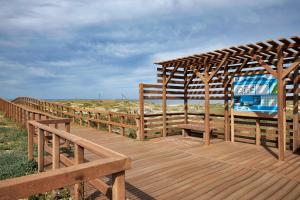 圣地亚哥-杜卡森apart@CostaSantoAndré Beach的海滩上带长凳的木甲板
