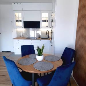 兹沃图夫Lux Apartment parking gratis的厨房配有木桌和蓝色椅子