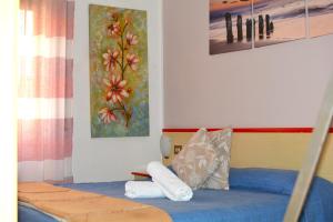 瓦拉泽HOTEL LA MADUNINA的一间卧室配有一张带蓝色床单和枕头的床。