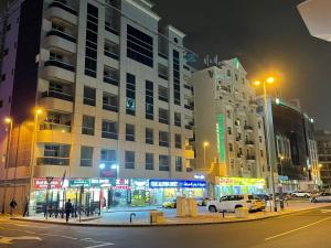 迪拜Pharos Inn Sheikh Zaied Private bed space的街道,夜间有汽车和建筑