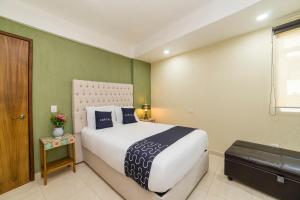 瓜纳华托Casa Santa Fe, Guanajuato的卧室设有一张白色大床和绿色的墙壁