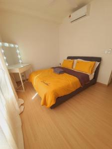 巴生Wallaway2stay Gravit8 Klang 2Room的一间卧室配有一张带黄床单和一张桌子的床。