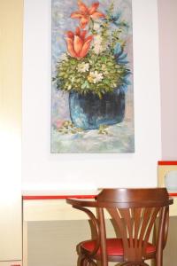 瓦拉泽HOTEL LA MADUNINA的花卉蓝色花瓶画