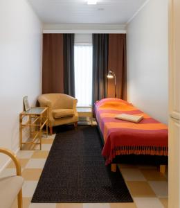 KauhajokiHostel Eduskunta的配有一张床和一把椅子的酒店客房