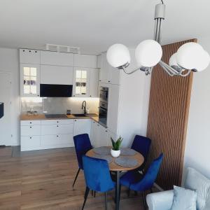 兹沃图夫Lux Apartment parking gratis的厨房以及带桌子和蓝色椅子的用餐室。