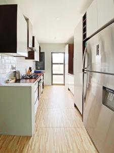 南迪GreyStone Apartments的厨房配有不锈钢冰箱和木地板