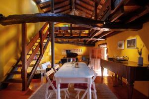 LongosCasa do Piano的一间设有白色桌子和楼梯的用餐室