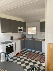 韦斯特罗斯Pärla med egen brygga的厨房配有灰色橱柜和 ⁇ 格地板