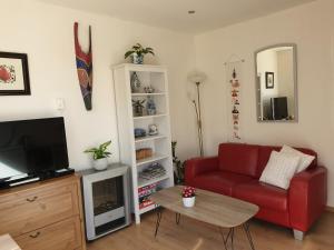 韦斯特卡佩勒Hout 25的客厅配有红色沙发和电视