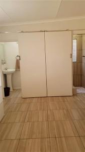 格拉夫-里内特Toni's Cottage的浴室设有白色门和木地板。