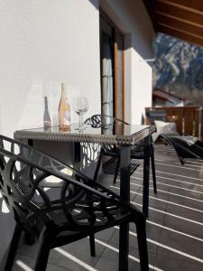 奥伯劳Das Bergquartier - Ferienwohnung Zugspitze的阳台上配有带葡萄酒瓶和玻璃杯的桌子