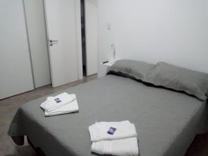 坦迪尔Departamento Ezeiza- ciudad de Tandil的一间卧室配有带毛巾的床