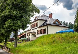 旧哈姆里Bezručova škola的山丘上的房子,前面有一辆蓝色的汽车