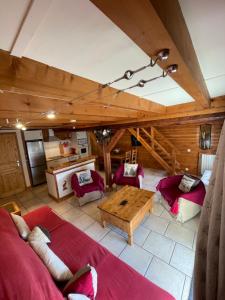 莱索尔Le CHAL HEUREUX bel appartement dans vieille ferme de montagne rénovée的客厅配有红色家具和木制天花板