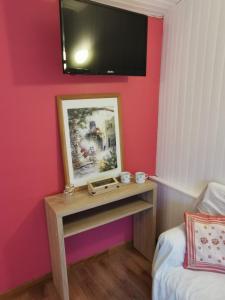 ArryLa maison de Céline的一间设有一张桌子的房间,墙上配有电视