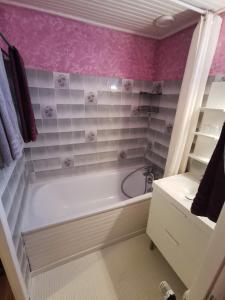 ArryLa maison de Céline的浴室设有白色浴缸和粉红色瓷砖