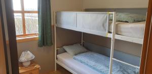 Fjall沃尔撒布2号度假屋的一间卧室设有两张双层床和一扇窗户。