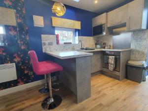 马特洛克Park House Studio的厨房配有柜台和粉红色凳子