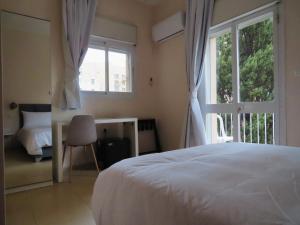 耶路撒冷B12 Inn的卧室配有白色的床和窗户。