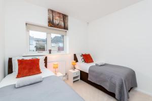 达特福德Lovely 2-Bed Apartment in Dartford的一间卧室设有两张床和窗户。