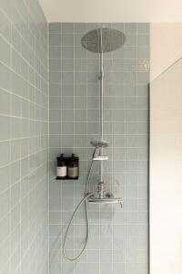 埃斯特雷莫斯Casa do Gadanha的浴室铺有蓝色瓷砖,设有淋浴。