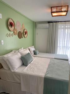 巴雷里尼亚斯Gran Lençóis Flat Residence Mandacaru 311 - 611的卧室配有两张床,墙上挂有帽子