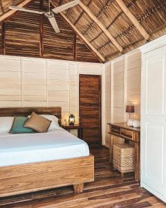 El LimónMonoloko Lodge Popoyo的一间卧室设有一张床和木制天花板