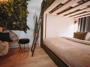 布雷达Abbey Green Lodge的一间卧室配有一张床、椅子和植物
