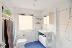 施莱登Toms Gästehaus的白色的浴室设有卫生间和水槽。