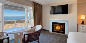 卡农海滩佳能海滩霍尔马克度假酒店的客厅配有桌子和壁炉
