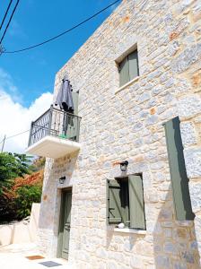 利梅尼Vina's Stone House的一栋石头房子的一侧设有阳台