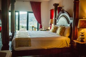 朱利安Quiet Mind Mountain Lodge, Retreat & Spa的一间卧室设有一张大床和大窗户
