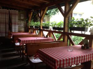 科马尔诺Penzion Duna的餐厅设有3张桌子,配有红色和白色的桌布