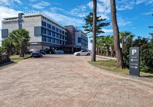 济州市Hotel Sweet Castle Jeju Hamdeok的大楼前的停车场