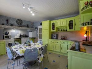 利梅伊Gîte Limeuil, 4 pièces, 6 personnes - FR-1-616-219的厨房配有绿色橱柜和桌椅
