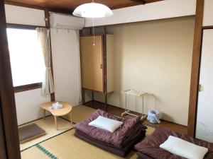 指宿市ゲストハウスまちかど Guest House MACHIKADO的客厅配有沙发和桌子