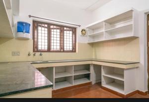 科钦Tharayil Apartments的一个带柜台和窗户的大厨房