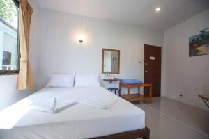 卡马拉海滩Kamala bay inn的卧室配有白色的床和镜子