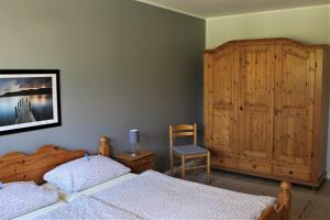 格洛米茨"Pappelhof - Whg 2"的一间卧室设有两张床和木制橱柜