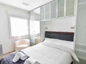 桑坦德Precioso apartamento reformado en el sardinero的卧室配有床、椅子和窗户。