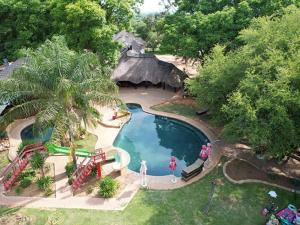 马布拉Hornbill Private Lodge Mabalingwe的享有带茅草屋顶游泳池的空中景致