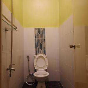 马尼拉bluenest apartment的一间带卫生间的浴室,拥有黄色的天花板